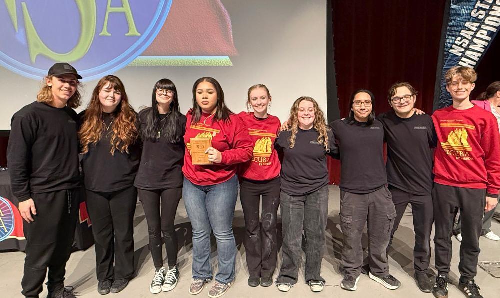 Nine students from Lincoln Northwest High School are standing in a row at the state play production contest. The person who is fourth from the left is holding the group's Class A state championship plaque. State judges honored the Falcons for their stage and audiovisual work at the state contest.