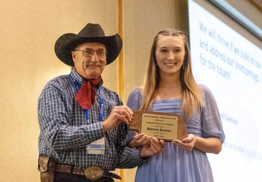 Lincoln High teacher Brenna Hansen smiles as she displays a state award at a National Council for Geographic Education event.