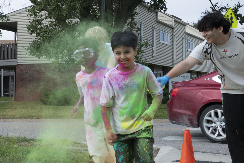 Two Lakeview Elementary students run as volunteers spray colored powder on them.