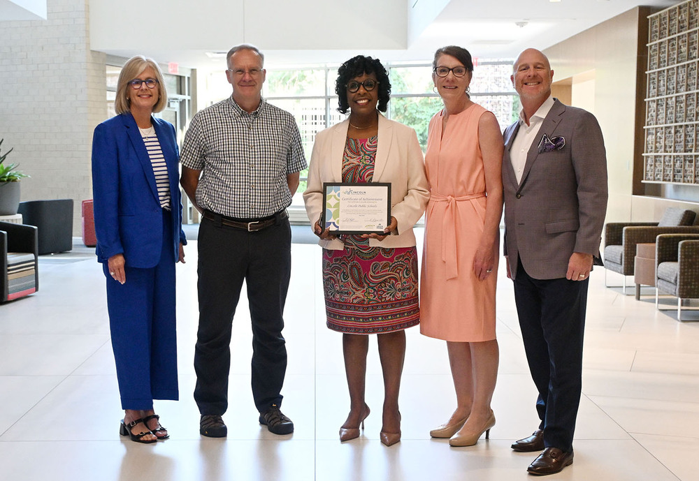Lincoln Public Schools has been recognized in the Lincoln Family-Friendly Workplace Certification Program. From left, Lincoln Littles Executive Director Anne Brandt, Lincoln Board of Education member Bob Rauner, LPS Associate Superintendent of Human Resources Vann Price, LPS Associate Superintendent of Business Affairs Liz Standish and Lincoln Partnership for Economic Development President Jason Ball stand together in a row. Vann Price is in the middle and is holding a rectangular certificate of achievement.
