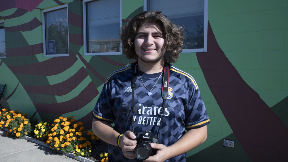 Arts and Humanities student holding a photo camera.