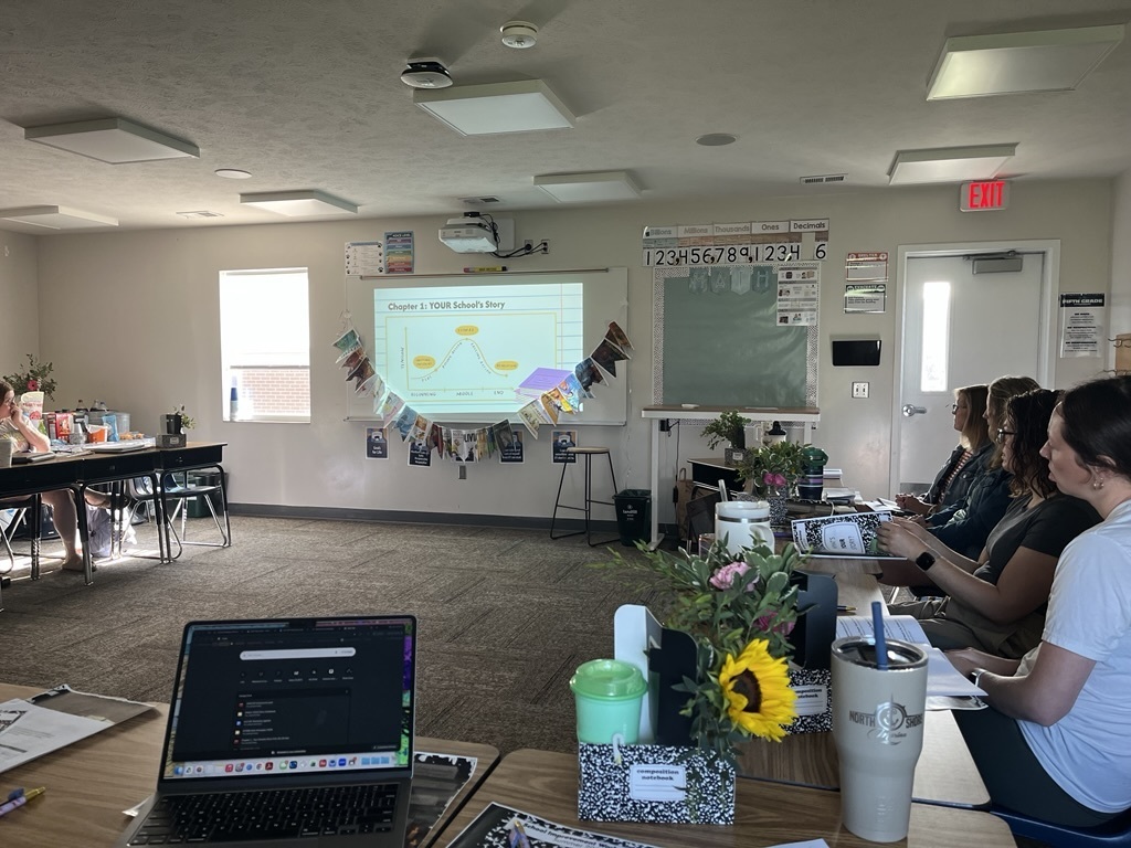 Teachers sitting at desk together, reflecting on the year and planning for the future. 