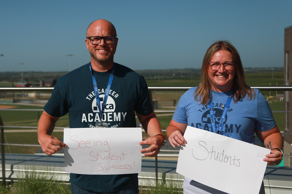 Mr. Jones holding "seeing student success" sign and Mrs. Crabtree holding "students" sign (this is what excites them about their work in LPS). 