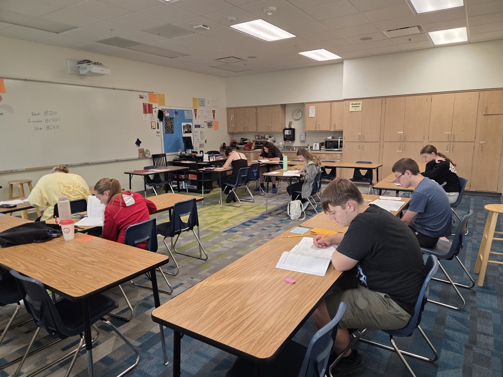 Students sitting at tables in a classroom complete their Sample ACT.