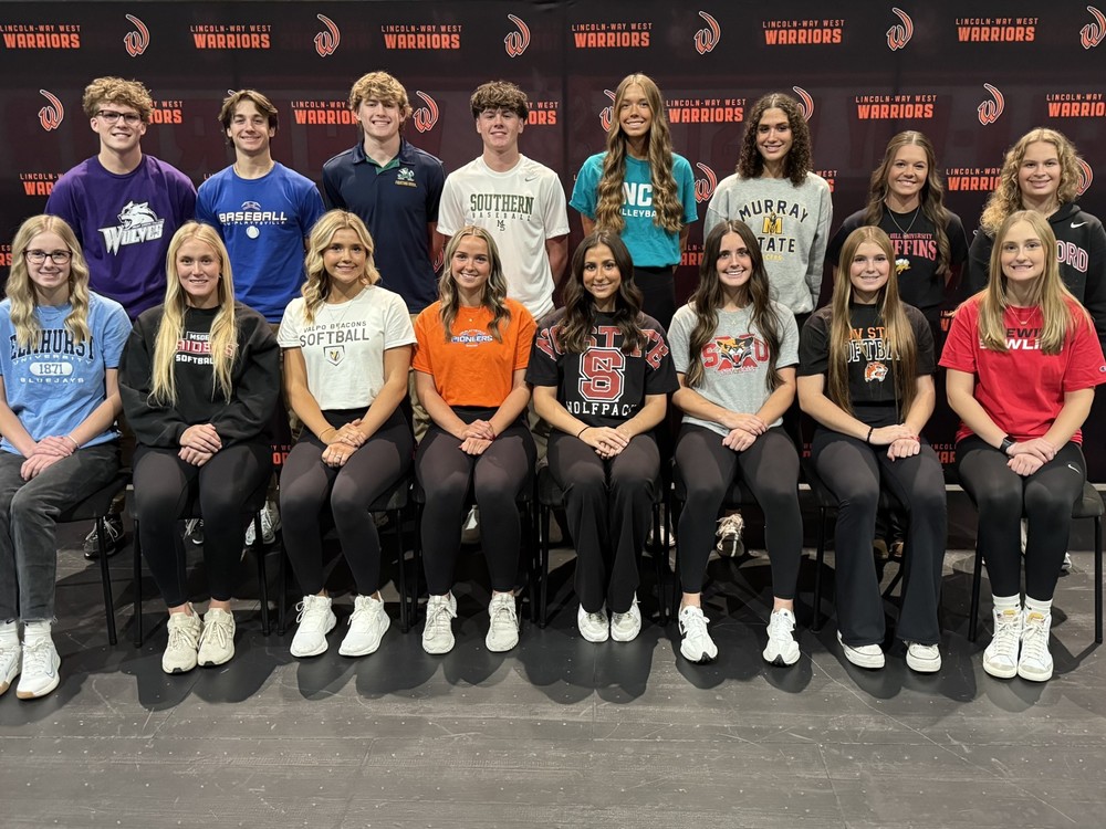 Student athletes posing for a photo in front of a LWW banner