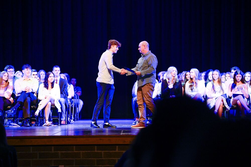 student receiving an award on stage in front of an audience