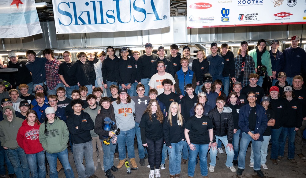 Many students posing for a photo standing under a banner that says Skills USA