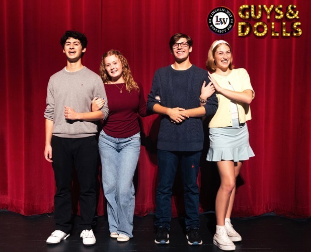 guys & dolls cast posing for a photo on stage