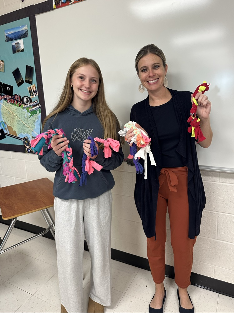 club members holding dog toys