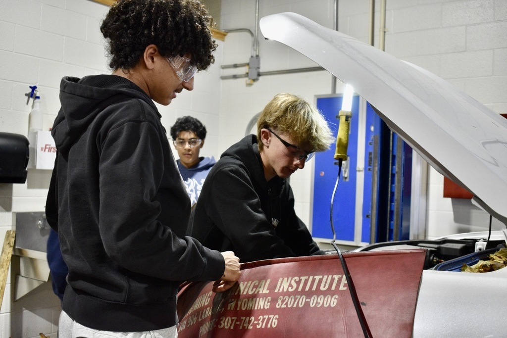 students working on a car
