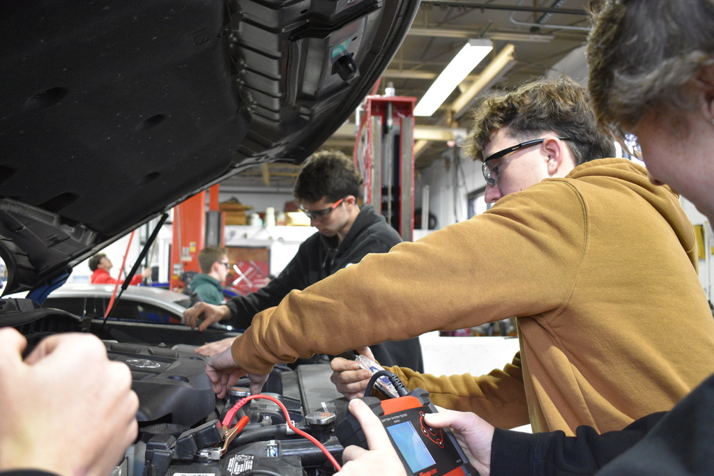 students working on a car