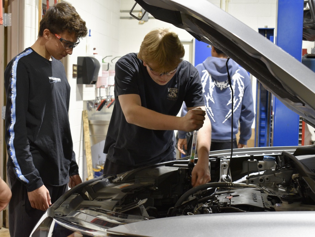 students working on a car