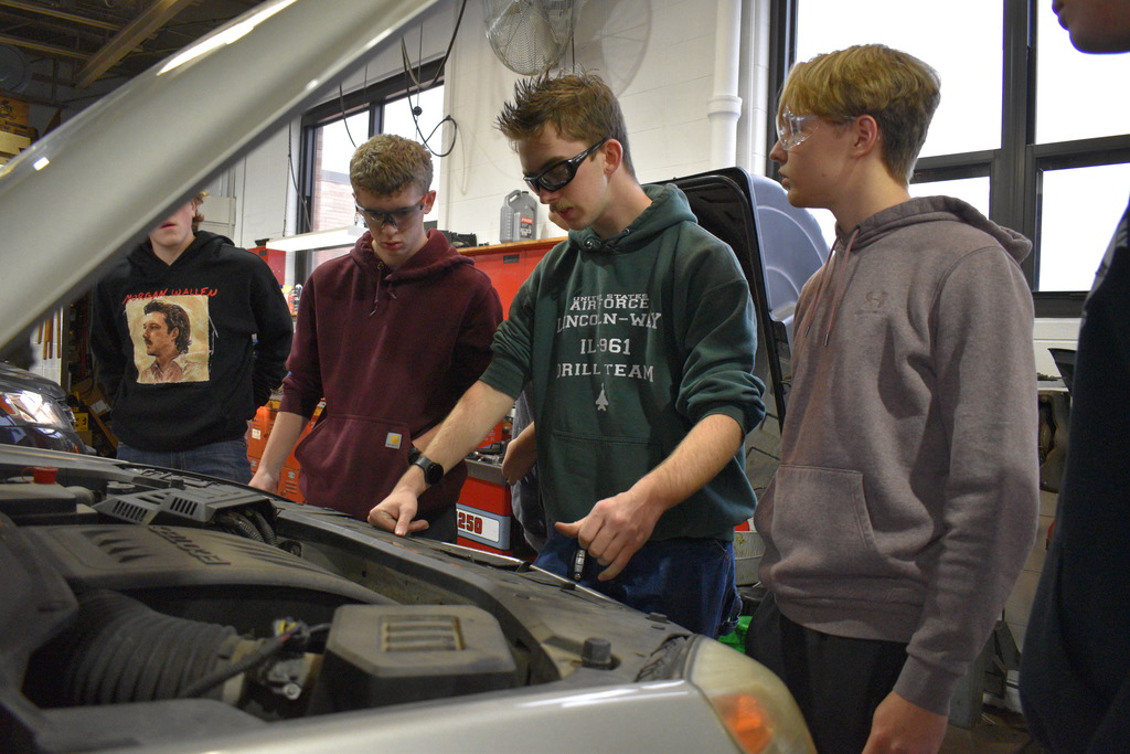 students working on a car
