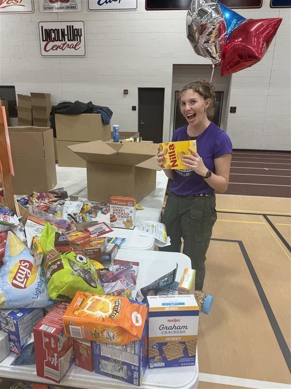 student placing food on a donation table