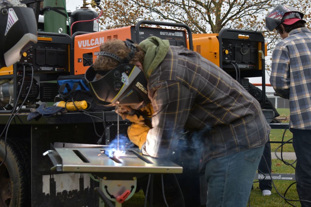 Students welding outside