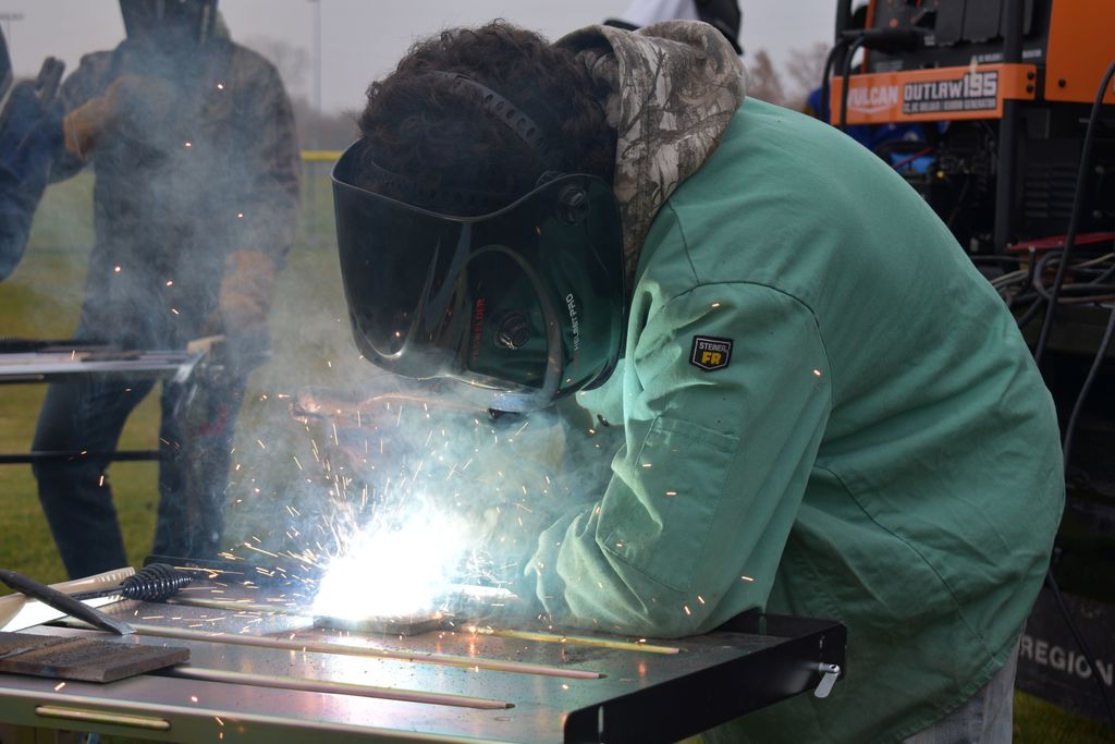 Students welding outside