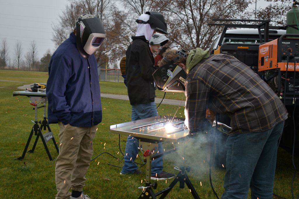 Students welding outside