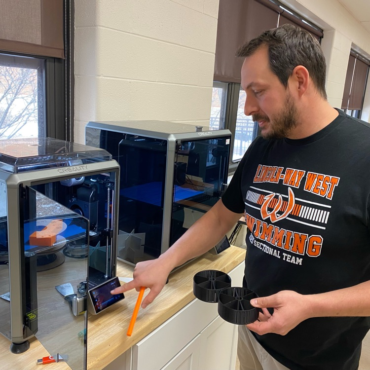teacher working with 3d printer