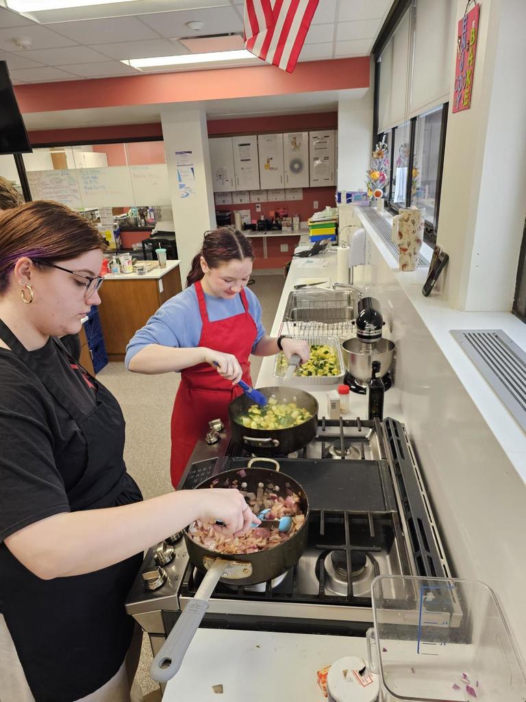 students cooking at a stove in the classroom kitchen