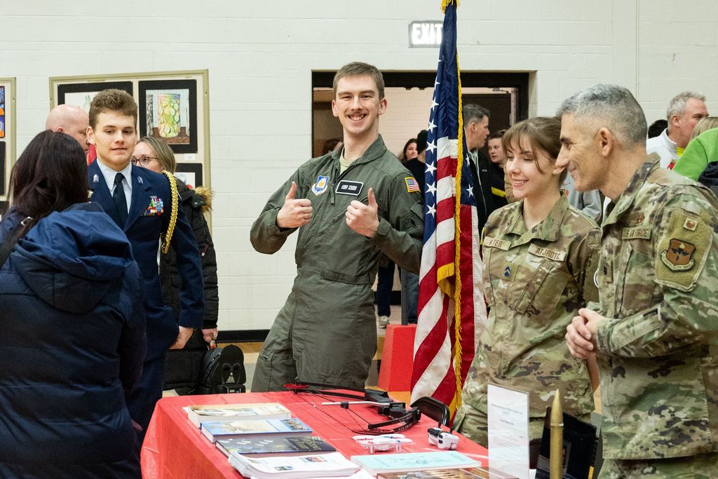 ROTC student giving thumbs up behind a table at Open House