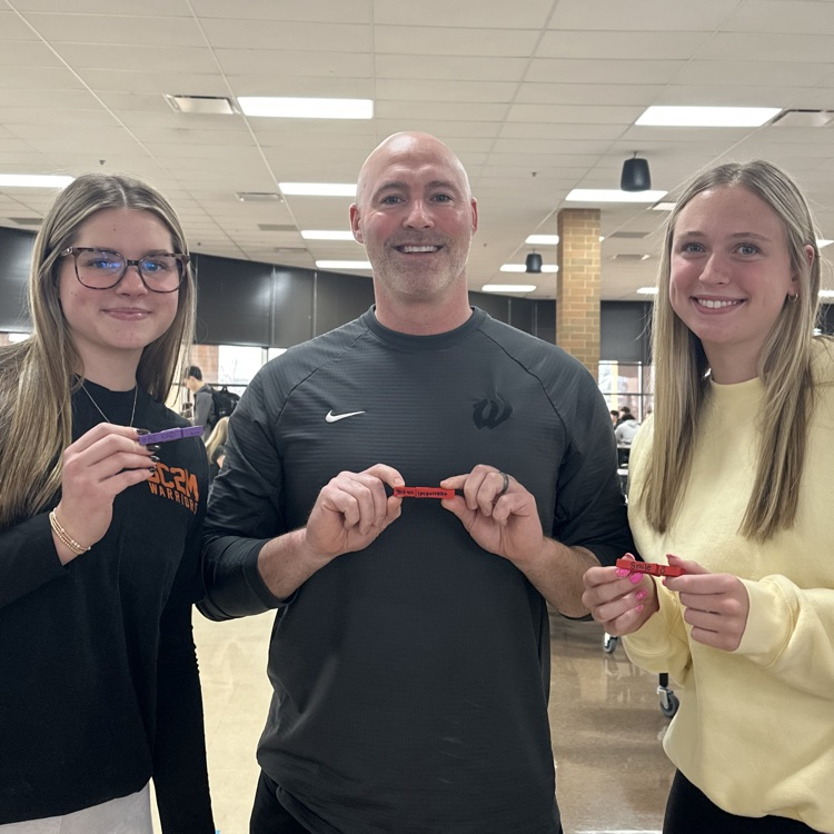 student and teacher holding kindness clips in the cafeteria