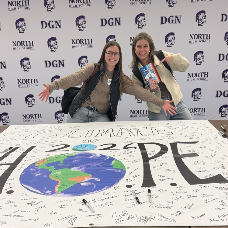 teachers in front of banner