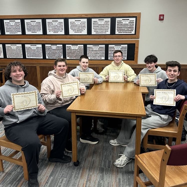 students holding certificates at a table