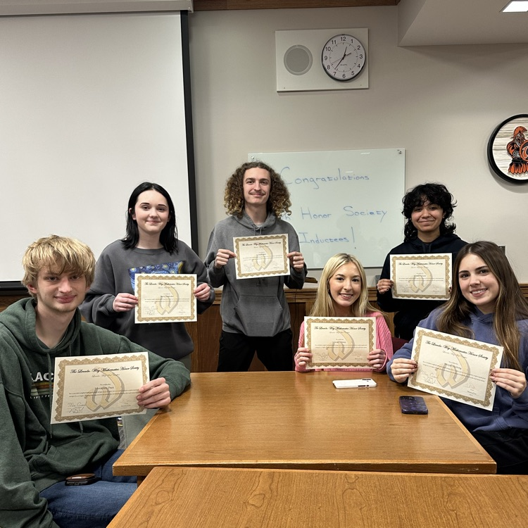 students holding certificates in front of a dry erase board 