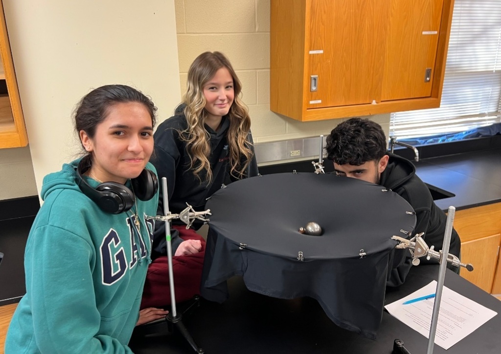 Mr. Tucker's Astronomy classes analyzed "space-time" surfaces by rolling marbles. This allowed students to see how mass warps space and how that curvature guides motion.
