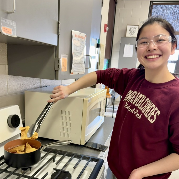 student cooking at stove