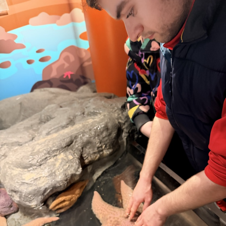 student touching a starfish