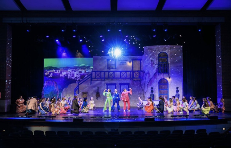 stage with cast singing and dancing