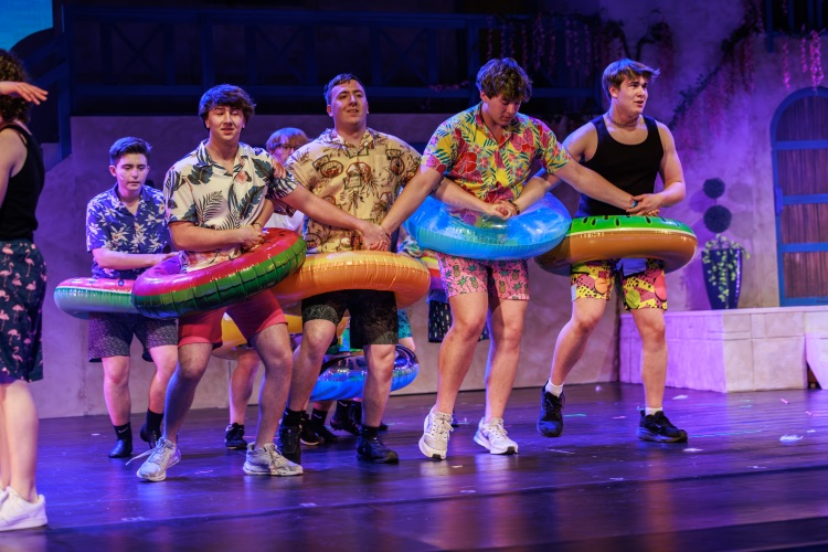 students on stage with props