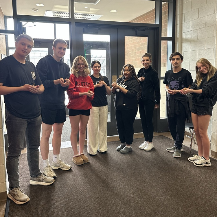 multiple students holding baby chicks in the hallway