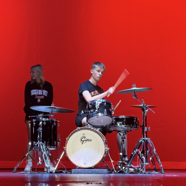 student playing the drums on stage