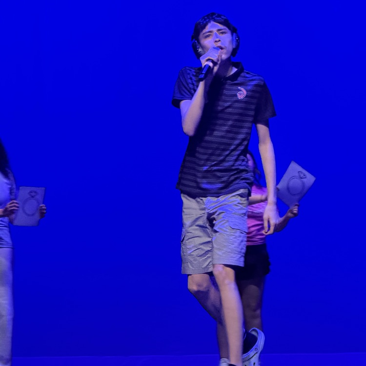 one student on stage with a microphone