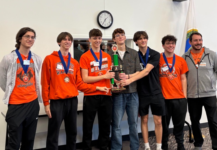 six students with the sponsor posing for a photo with the trophy at the event