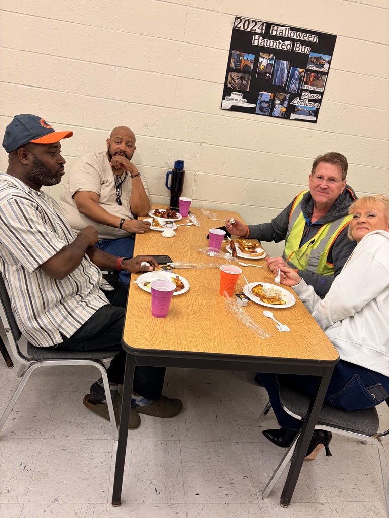 Bus driver appreciation breakfast, drivers sit at a table with food on plates and colorful cups, smiling