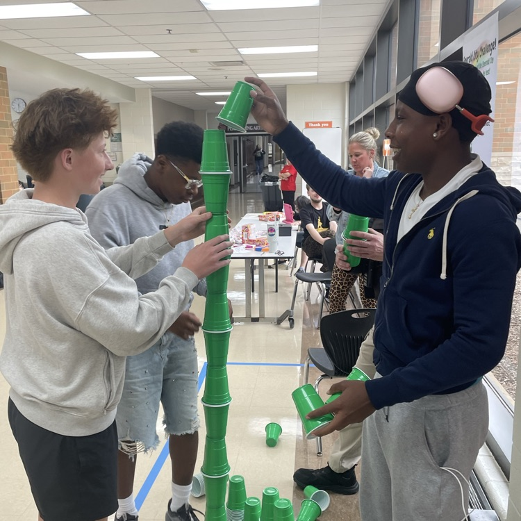 a few students stacking cups to make a tower in the cafeteria 
