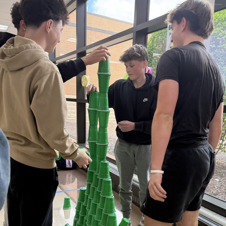 four kids and a tall tower of green cups