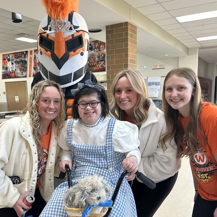 four students in Oz themed outfits with the mascot