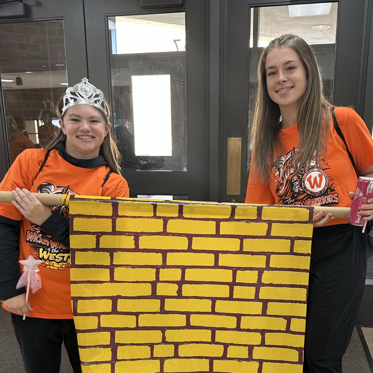two students posing with a yellow brick road