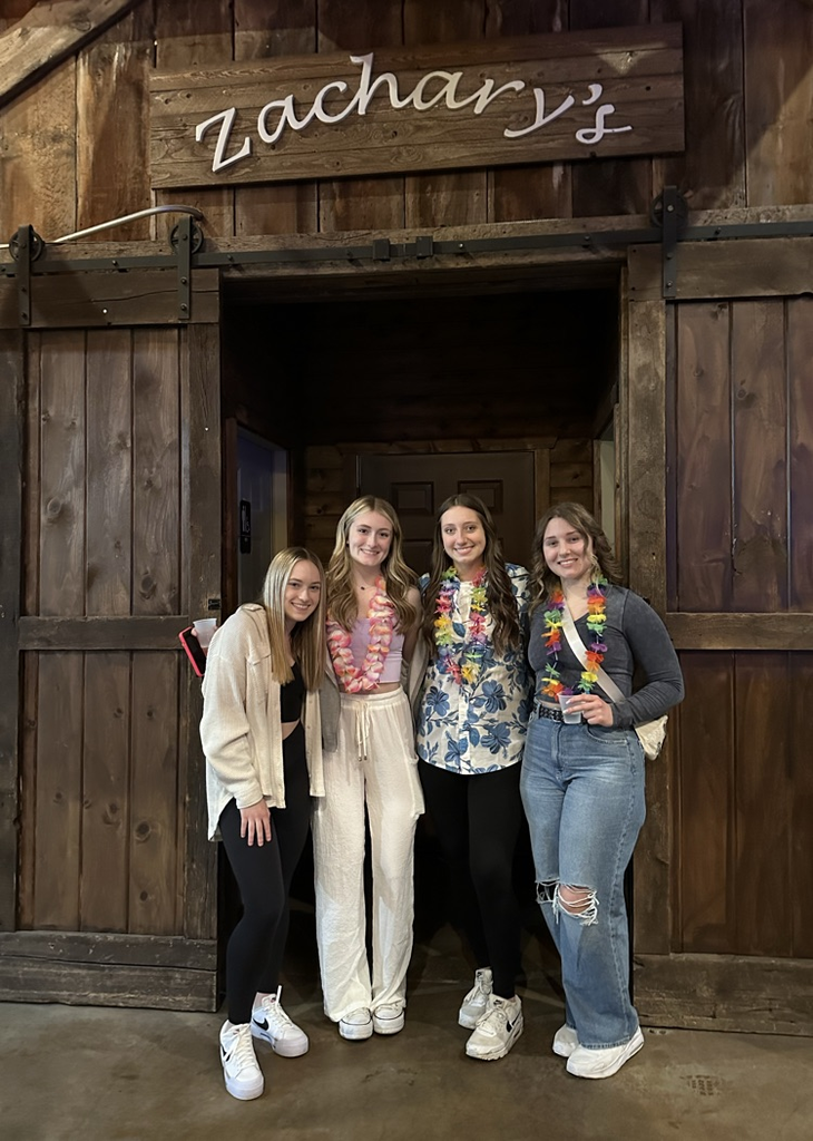 four students posing for a photo at the event