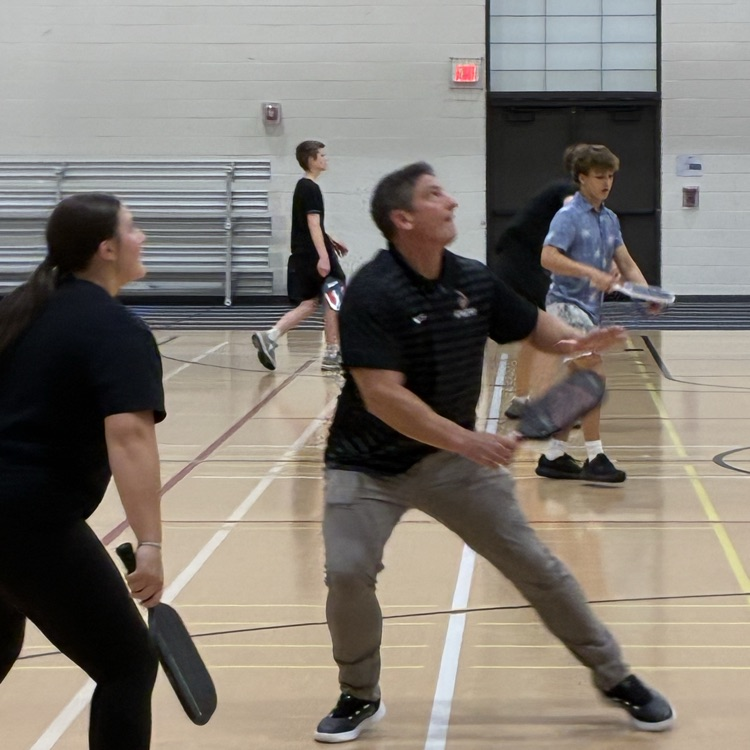 staff member and students playing pickleball