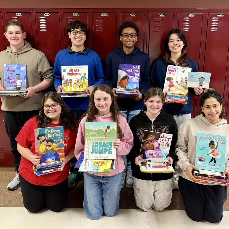 group of students holding up children’s books