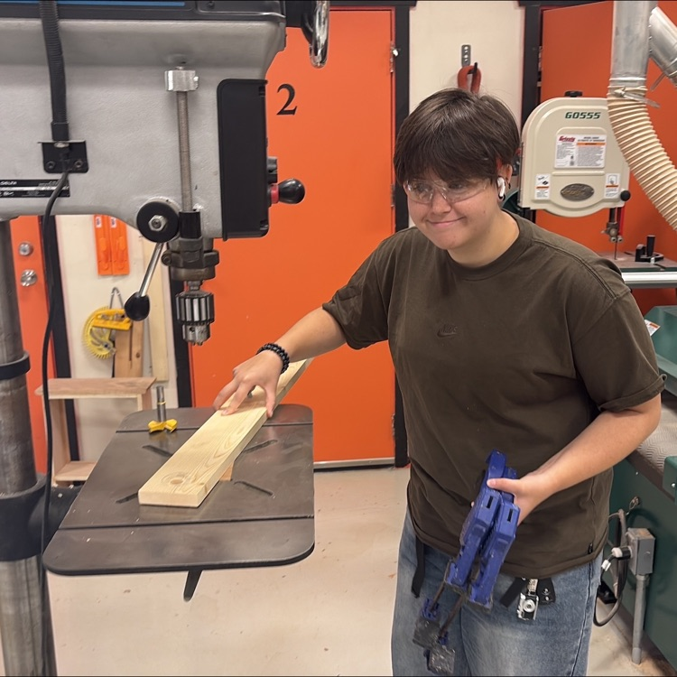 one student cutting wood