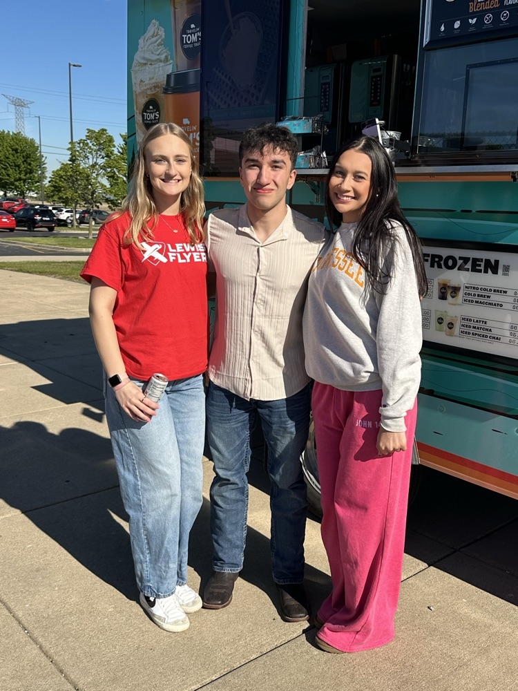 three students in front of food truck
