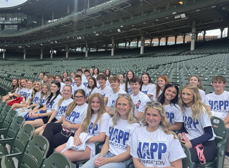 students posing for photos in bleachers