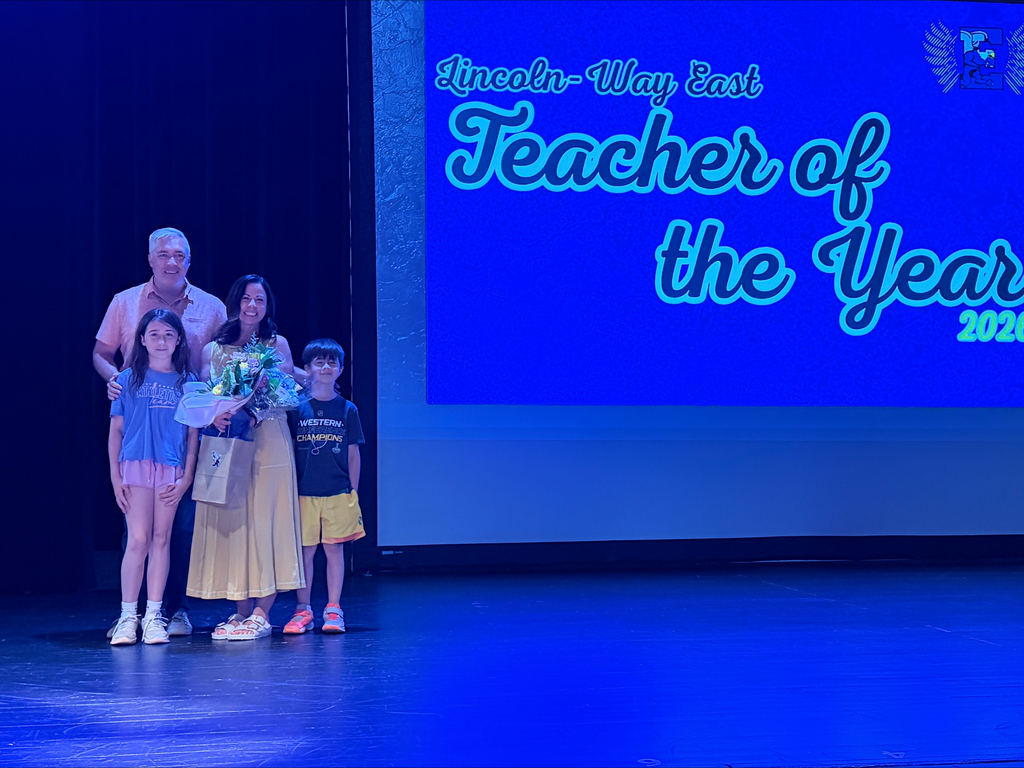Mrs. Cavanaugh poses for a picture with her family on stage.