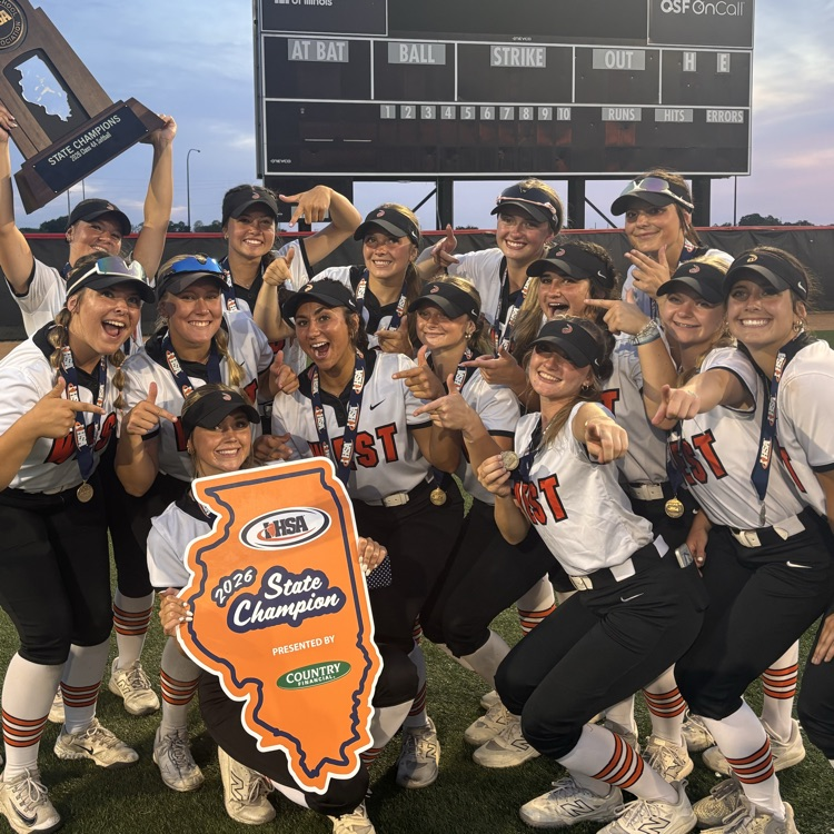 team holding state trophy in front of scoreboard